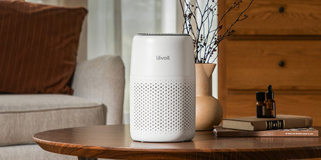 Levoit air purifier on a wooden table in a living room setting